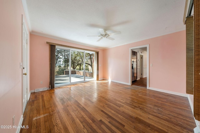 unfurnished room featuring baseboards, visible vents, ceiling fan, hardwood / wood-style flooring, and crown molding