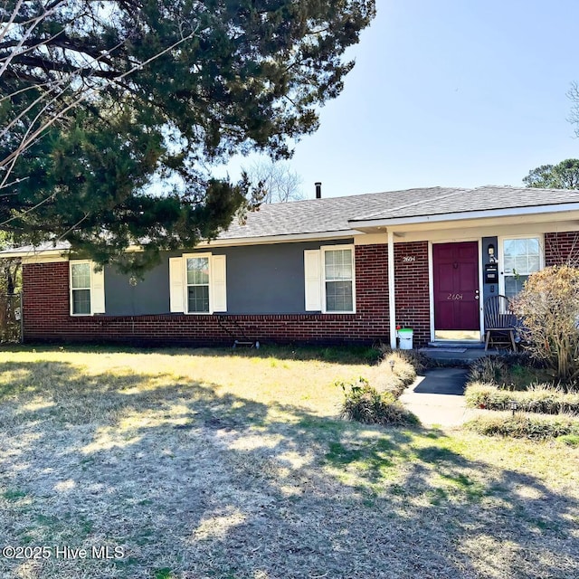 ranch-style home with a front lawn, brick siding, and a shingled roof