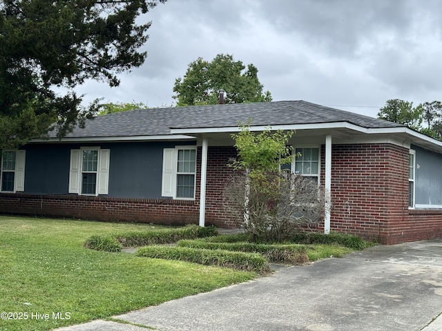 2604 Robeson St, Wilmington, NC 28405 - ranch-style house featuring brick siding, a front lawn, and a shingled roof