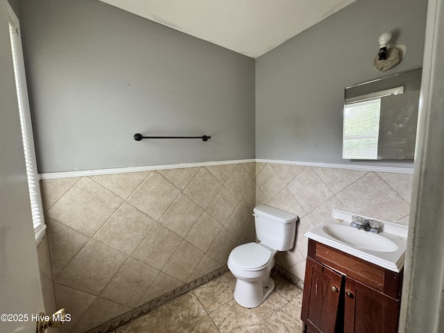 2604 Robeson St, Wilmington, NC 28405 - half bath with toilet, vanity, tile patterned flooring, a wainscoted wall, and tile walls