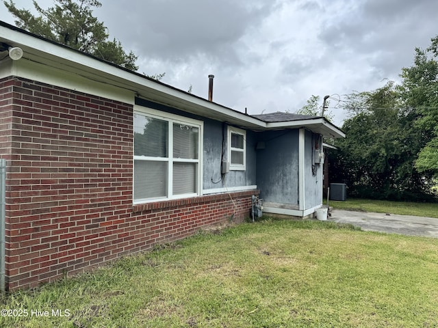 2604 Robeson St, Wilmington, NC 28405 - view of side of property featuring central AC unit, a lawn, and brick siding
