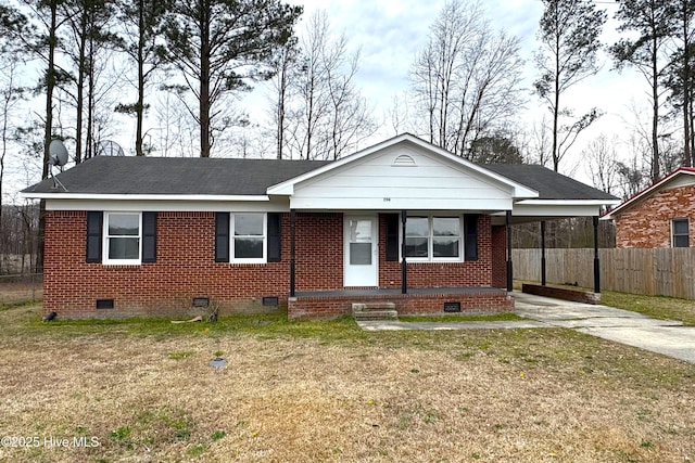 view of front of house featuring brick siding, a front lawn, a carport, fence, and crawl space