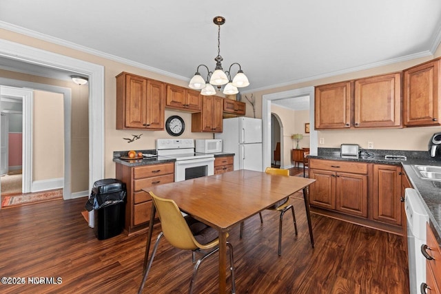 kitchen with white appliances, a notable chandelier, dark countertops, and dark wood-style floors