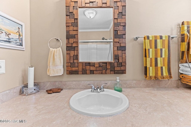 bathroom featuring ornamental molding and a sink