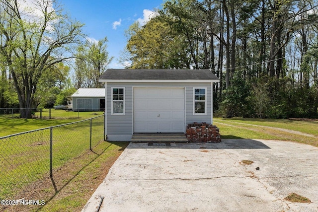 garage featuring fence and driveway