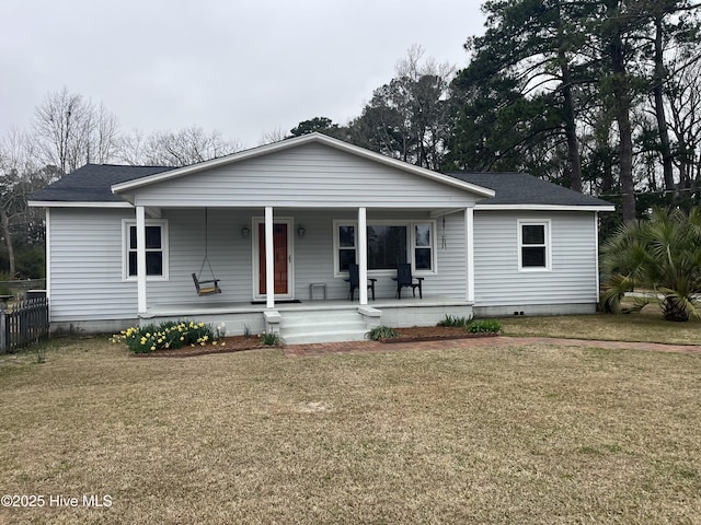 view of front of house featuring covered porch, a shingled roof, and a front lawn