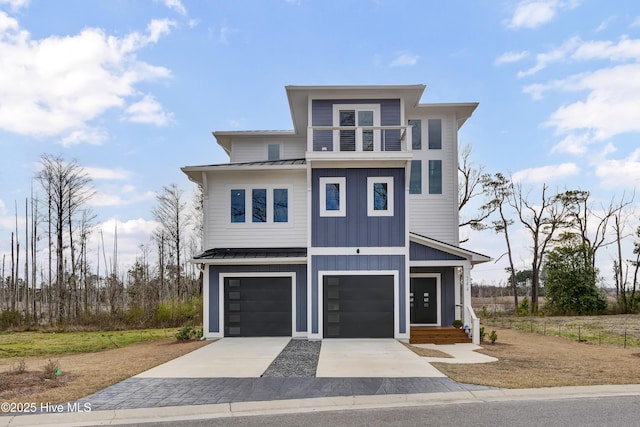 view of front of home with a garage, a standing seam roof, board and batten siding, concrete driveway, and metal roof