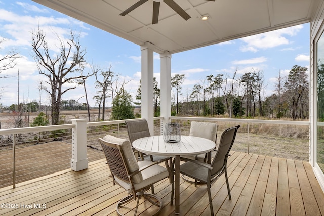 wooden deck with outdoor dining space and ceiling fan