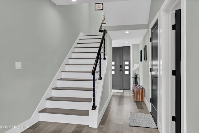 stairway featuring recessed lighting, baseboards, and wood finished floors