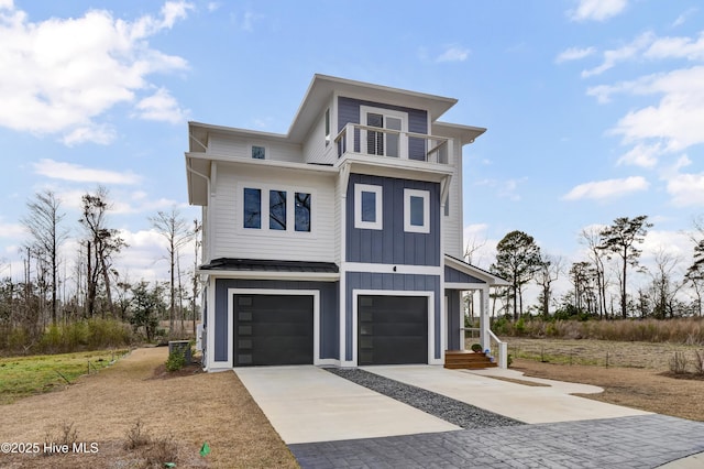 view of front of home featuring driveway, a standing seam roof, board and batten siding, metal roof, and a balcony