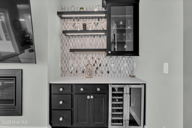 bar with a dry bar, beverage cooler, and backsplash