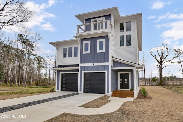 view of front facade featuring driveway, board and batten siding, an attached garage, metal roof, and a balcony