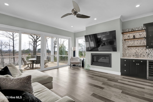 living room with crown molding, recessed lighting, wood finished floors, and ceiling fan