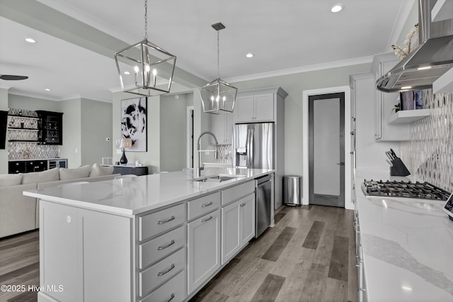 kitchen with a sink, open shelves, stainless steel appliances, crown molding, and wall chimney range hood