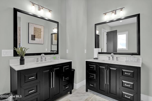 bathroom featuring two vanities, marble finish floor, and a sink