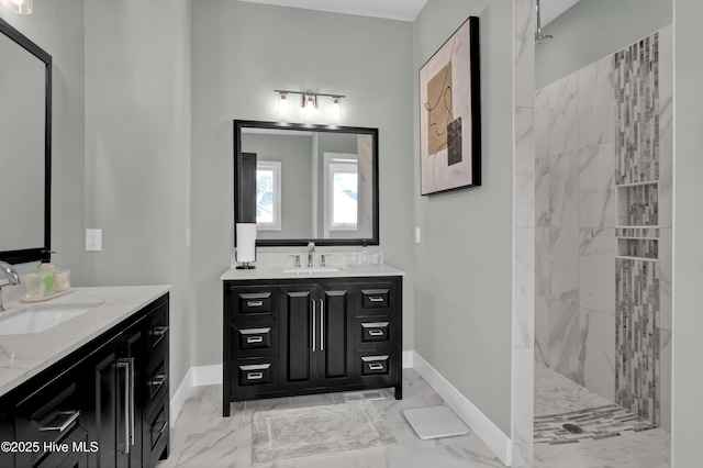 full bath with two vanities, a walk in shower, marble finish floor, and a sink