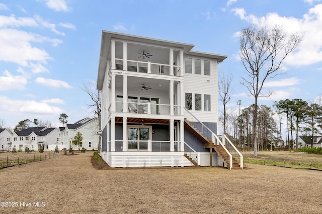 back of property featuring a balcony, stairway, a ceiling fan, and a sunroom