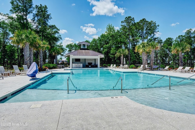 community pool featuring fence and a patio area