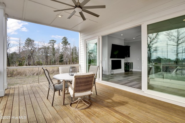 deck with outdoor dining space and a ceiling fan