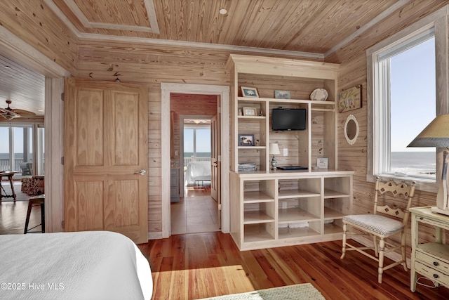 bedroom with wooden walls, wood ceiling, and wood finished floors