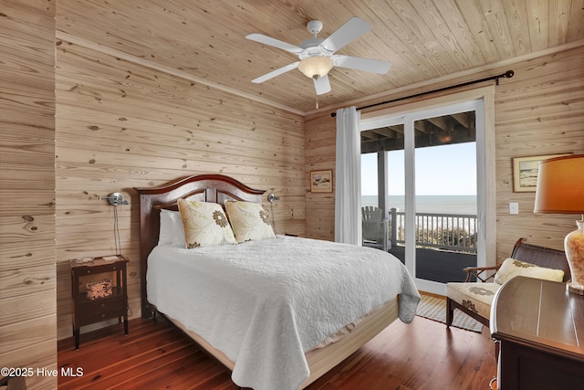 bedroom featuring a water view, wooden ceiling, wood walls, and access to exterior