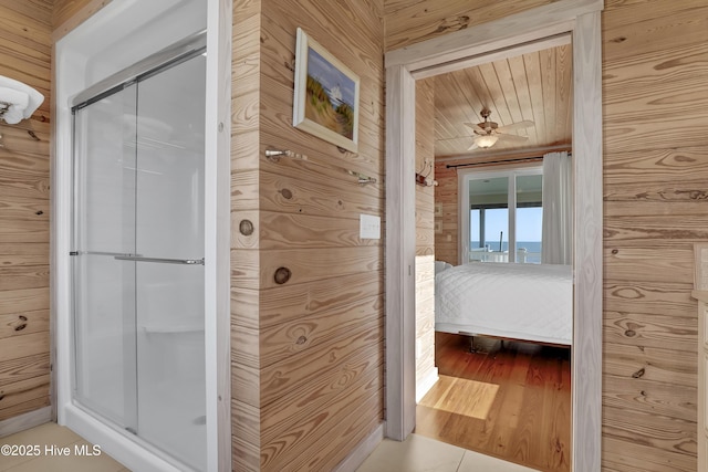 ensuite bathroom with wooden walls, ensuite bath, and a shower stall