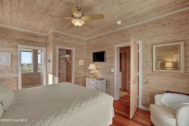 bedroom with wood walls, wood ceiling, ceiling fan, and wood finished floors