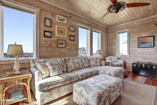 living area with wooden ceiling, wood finished floors, a wealth of natural light, and ceiling fan