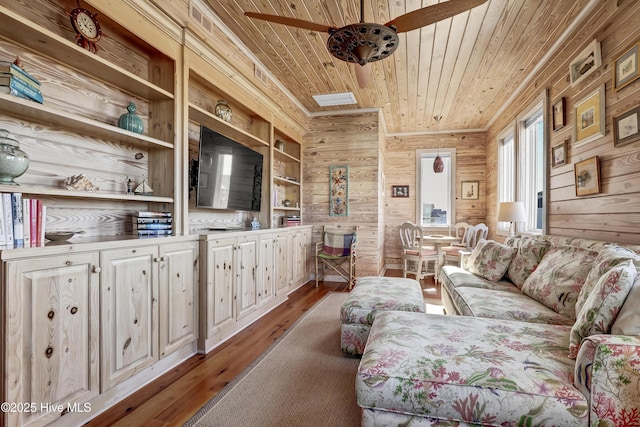 living room featuring wooden walls, wooden ceiling, ceiling fan, and wood finished floors