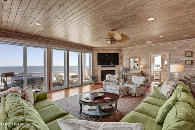 living room with a ceiling fan, wood finished floors, a healthy amount of sunlight, and wooden ceiling