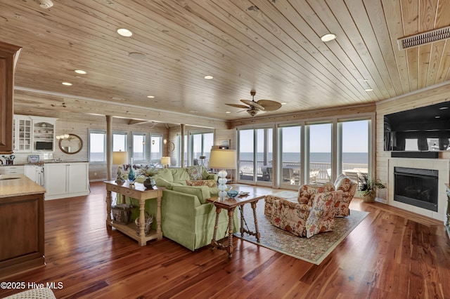 living room with visible vents, plenty of natural light, wood ceiling, and wood finished floors