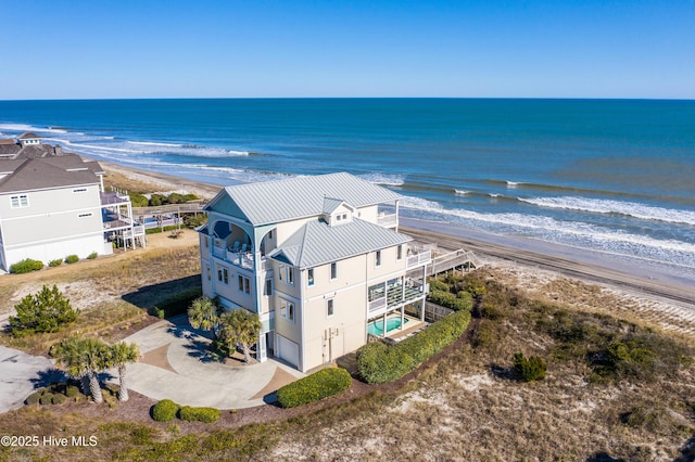 birds eye view of property featuring a water view and a beach view