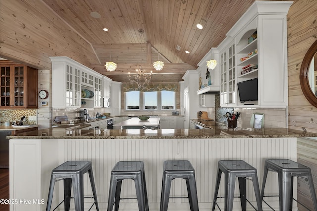 kitchen featuring open shelves, backsplash, dark stone counters, wooden ceiling, and vaulted ceiling