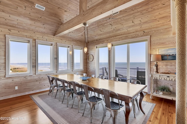 dining area featuring a wealth of natural light, lofted ceiling with beams, and wood finished floors