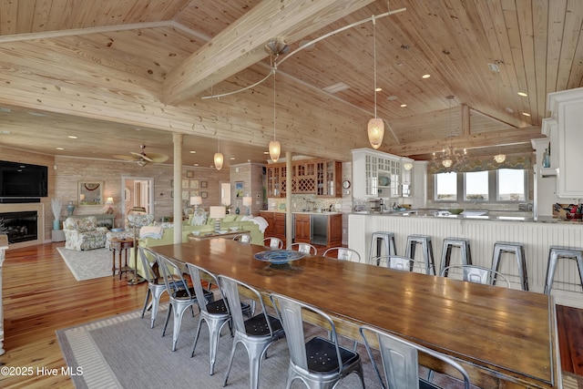 dining area with beamed ceiling, high vaulted ceiling, wood ceiling, and light wood-style flooring