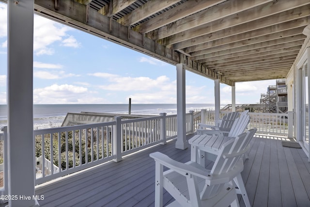 wooden deck with a beach view and a water view