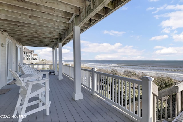 deck with a view of the beach and a water view