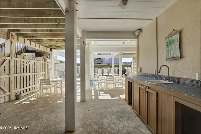 view of patio / terrace featuring fence and a sink