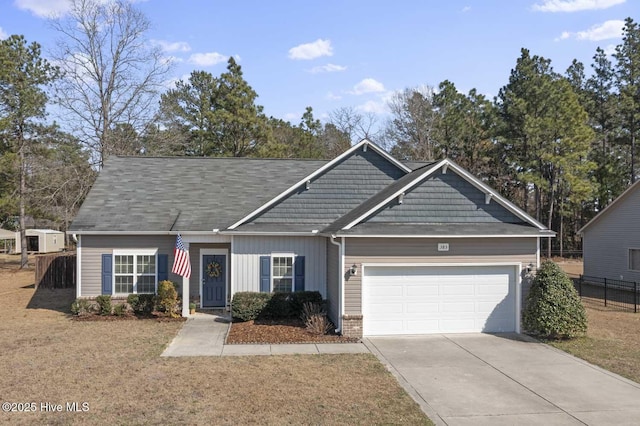 view of front facade with driveway, fence, a front yard, a garage, and brick siding