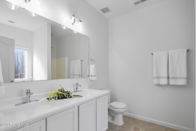 bathroom with toilet, visible vents, and a sink