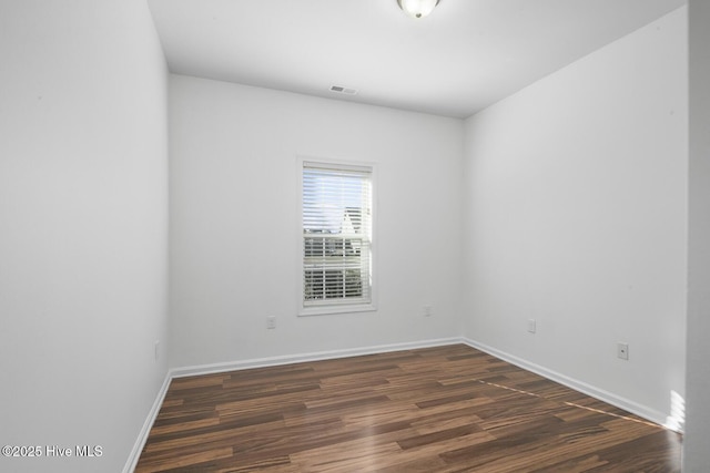 empty room with visible vents, baseboards, and wood finished floors