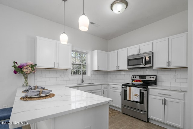 kitchen with tasteful backsplash, a peninsula, stainless steel appliances, white cabinetry, and a sink