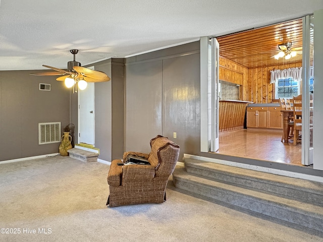 sitting room with visible vents, carpet flooring, a textured ceiling, and ceiling fan