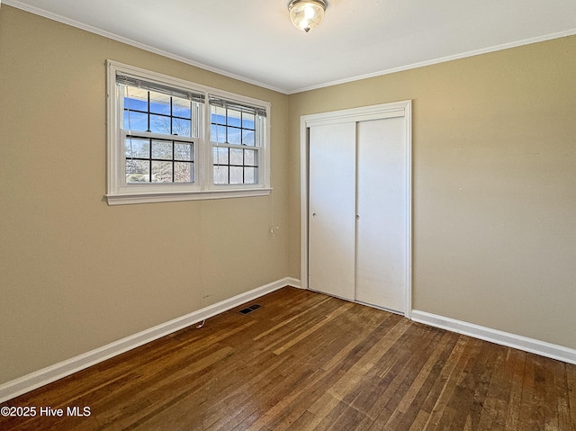 unfurnished bedroom featuring dark wood-style floors, visible vents, and baseboards