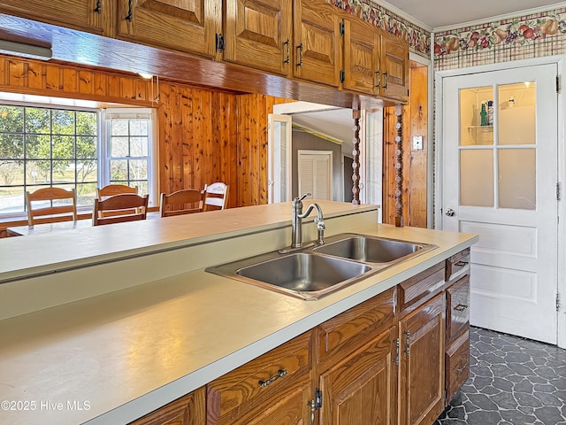 kitchen featuring brown cabinetry, light countertops, and a sink