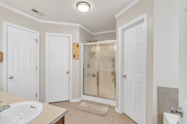 bathroom featuring tile patterned floors, visible vents, a shower stall, crown molding, and vanity