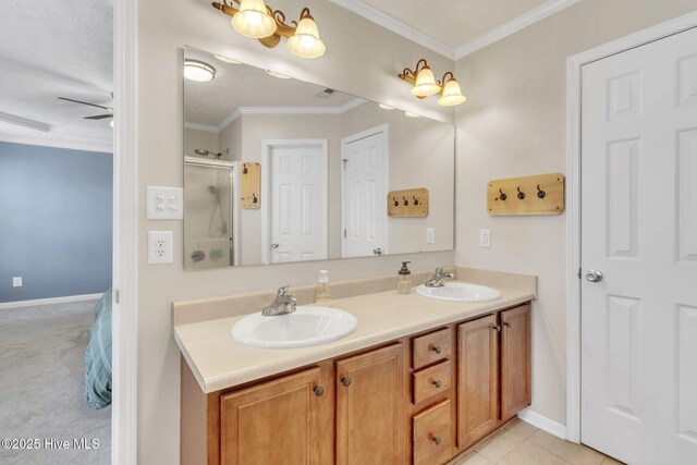bathroom with ceiling fan, double vanity, ornamental molding, and a sink