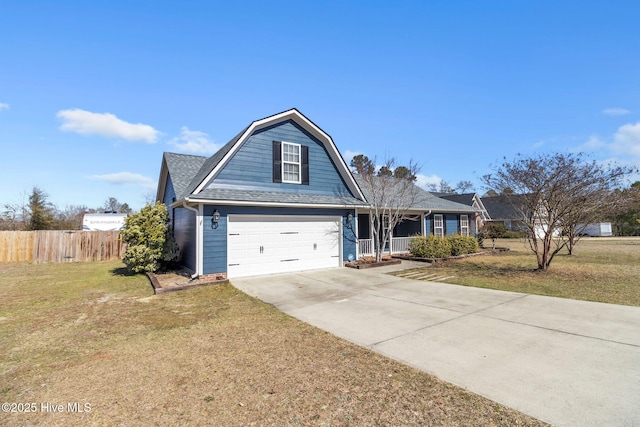 view of front facade with fence, roof with shingles, a gambrel roof, a front lawn, and concrete driveway