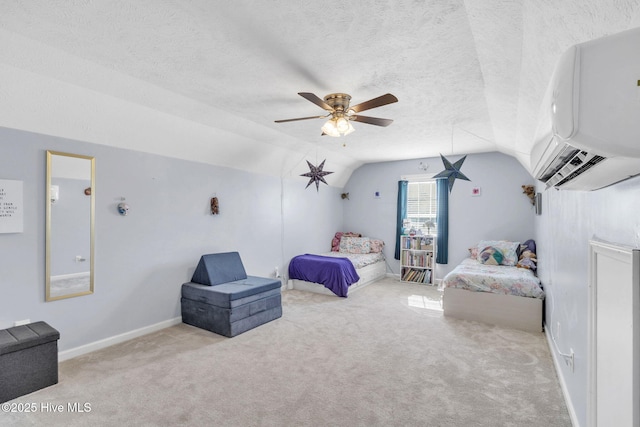 carpeted bedroom with a wall mounted air conditioner, a textured ceiling, baseboards, ceiling fan, and vaulted ceiling