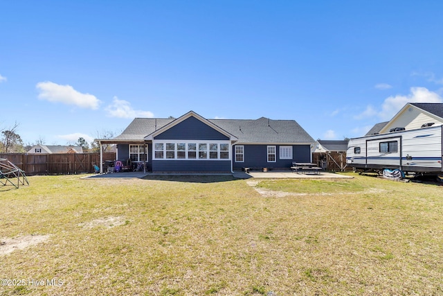 rear view of property with a yard, a patio, and a fenced backyard